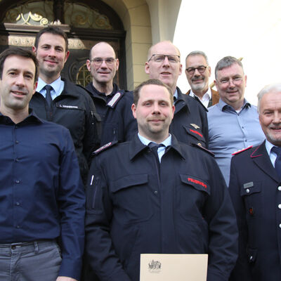 Gruppenfoto mit Marcel Lotze, dem Bürgermeister und Feuerwehr-Funktionären.