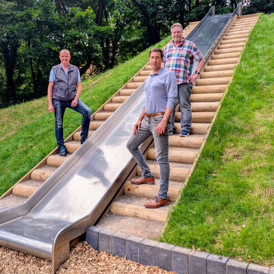 (V.li.) Ivo Schwarz (Fachdienstmitarbeiter Gr�nanlagen und Friedhofswesen), B�rgermeister Tobias Dannenberg und Andreas Honeck (Fachdienstleiter Gr�nanlagen und Friedhofswesen) an der sanierten Rutsche auf dem Spielplatz am Wall.
