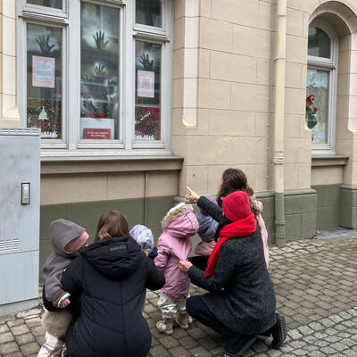 Kinder und Erzieherinnen betrachten ihr Werk am Markt.