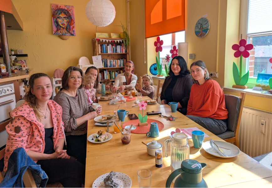(V.re.) Madlien Wienberg, Melissa Castillo und Tina Krause (2.v.li.) mit einigen M�ttern und Kindern beim Fr�hst�ck im Familienzentrum.