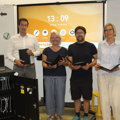 (V.li.) B&uuml;rgermeister Tobias Dannenberg, Nadine Hinze, Schulleiterin Grundschule am Wall, Philipp Speck, kommissarischer Schulleiter der Grundschule Hermannshagen und Simone Schulenberg, Schulleiterin der Grundschule Hedem&uuml;nden in einem Klassenraum der Grundschule am Wall. Digitale Tafel und Tablets f&uuml;r Sch&uuml;lerinnen und Sch&uuml;ler stehen dort ab sofort f&uuml;r die p&auml;dagogische Arbeit bereit.
